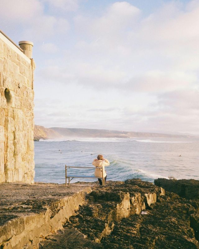 Person by the ocean in Ericeira, Portugal, looking out over the Atlantic during a quiet moment of reflection
